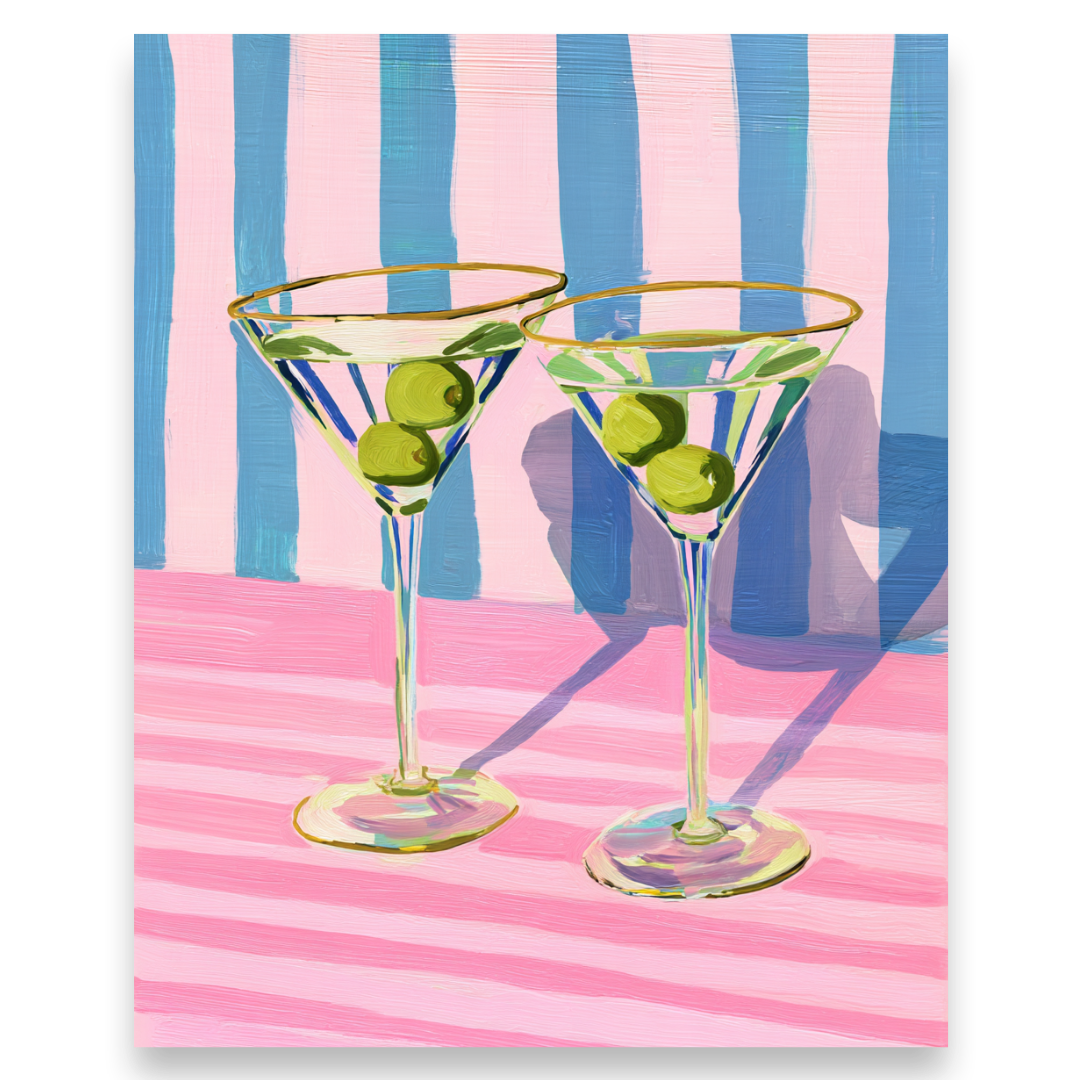 Two martini glasses with olives on a pink and blue striped background