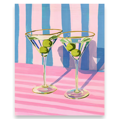 Two martini glasses with olives on a pink and blue striped background